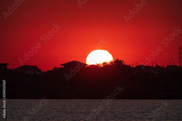 Fototapeta The sun goes down over a lake