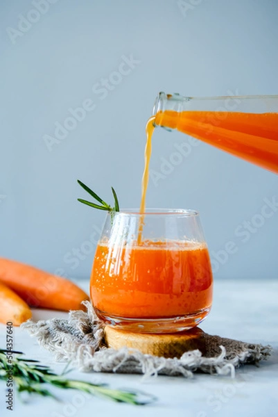 Obraz Carrot juice in a glassy glass. Freshly lived carrot juice. Orange carrot juice. Vegetable juice