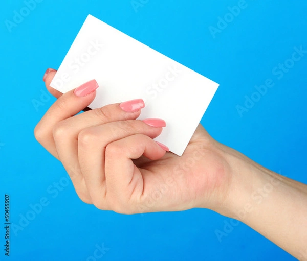 Fototapeta Female hand holding business card, on color background
