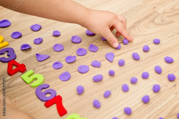 Obraz Play-Doh stones and numbers. Counting DIY game. Mathematical task. Play at home. Way of learning. Kid flatten balls when saying a digit.