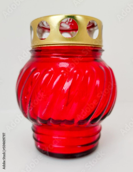 Fototapeta An unquenchable lamp made of red glass. Candle for the grave with a lid. A memorial candle. A memory candle.