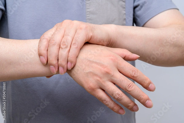 Fototapeta A man wrapped around his wrist because of wrist pain. Causes of rheumatoid arthritis, carpal tunnel syndrome, gout. Health care and medical concept.