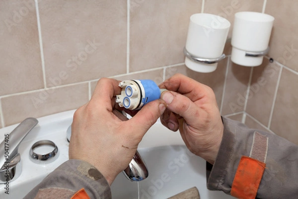 Fototapeta Plumber fixing water tap ceramic cartridge valve