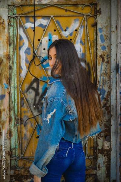 Obraz long-haired girl, with her back turned, looks at the camera