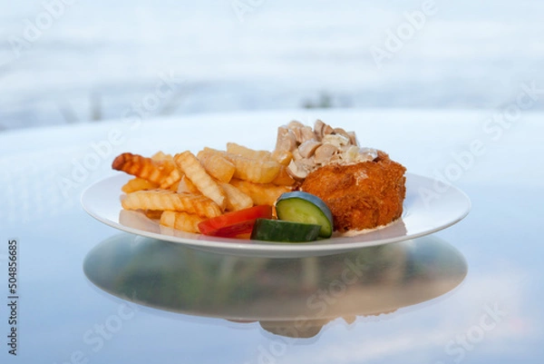Fototapeta Appetizing dish with French fries and kebab. Potatoes and meat ready to eat on a plate. Tasty food.