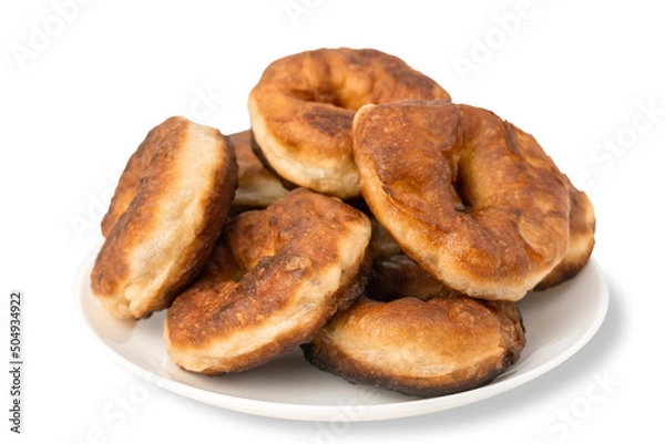 Fototapeta Pile of fresh homemade round donuts in a plate isolated on white background. Brown fried doughnuts. Yeast dough products, sweet pastries isolate.