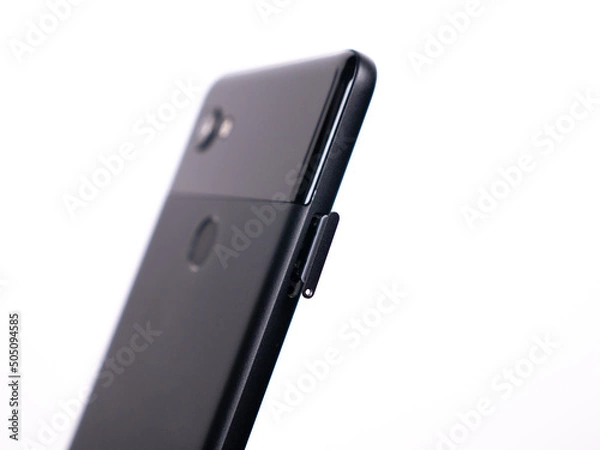 Fototapeta SIM tray for SIM card in smartphone close-up view on a white background