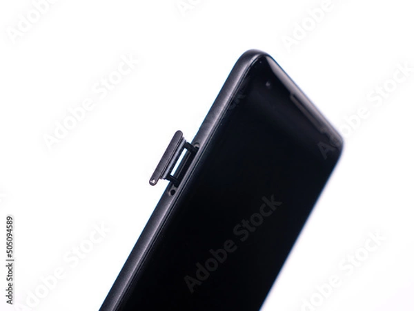 Fototapeta SIM tray for SIM card in smartphone close-up view on a white background