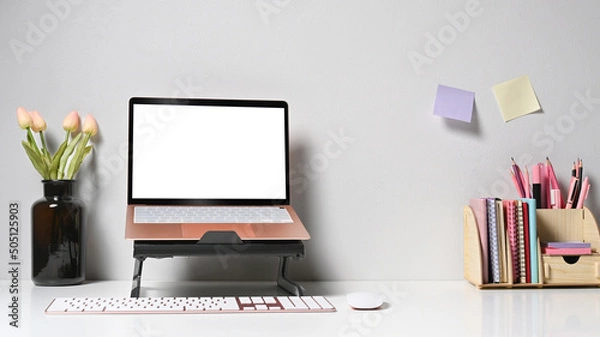 Fototapeta Computer laptop with blank screen, flower pot and coffee cup on white table