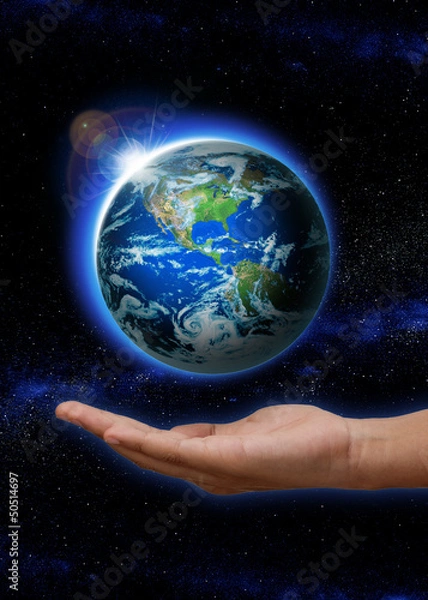 Obraz Hand holding Rising Sun over the world, Planet earth in space