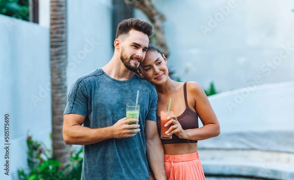 Obraz Young happy couple drinking smoothie.