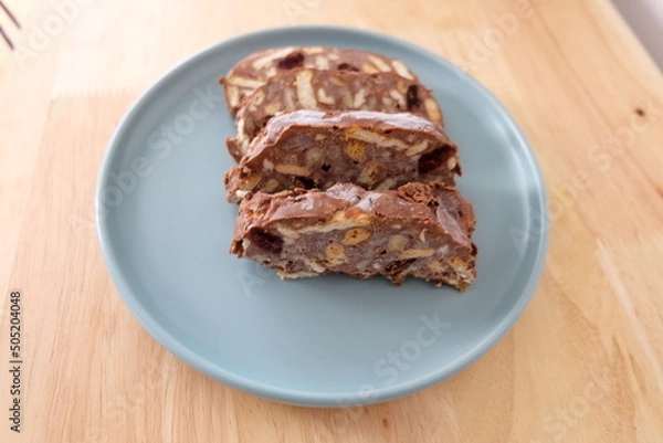Fototapeta Homemade mosaic chocolate biscuit cake served in a blue plate, selective focus. It is called "Mozaik Pasta" in Turkish. That is texture of it not grain. Traditional Turkish dessert.