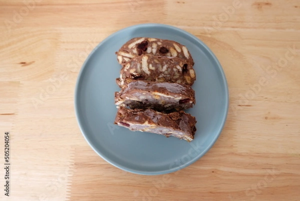 Fototapeta Homemade mosaic chocolate biscuit cake served in a blue plate, selective focus. It is called "Mozaik Pasta" in Turkish. That is texture of it not grain. Traditional Turkish dessert.