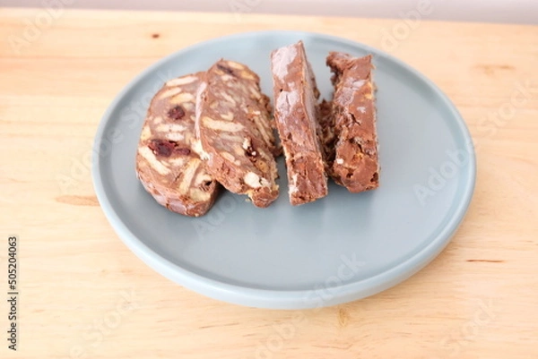 Fototapeta Homemade mosaic chocolate biscuit cake served in a blue plate, selective focus. It is called "Mozaik Pasta" in Turkish. That is texture of it not grain. Traditional Turkish dessert.