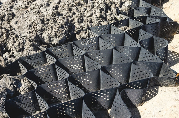 Obraz Black geogrid filled with soil for steep hill stability. Soil erosion control.