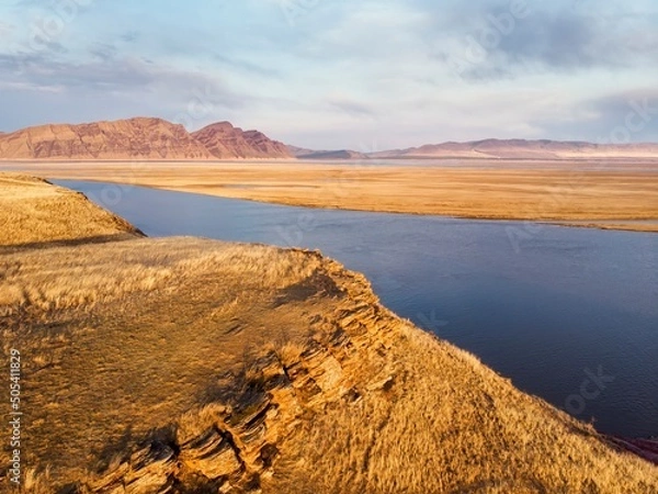 Obraz Rocks on the shore of the Krasnoyarsk reservoir without water, riverbed, sunset and rainy sky over Mount Tepsey Tepsei