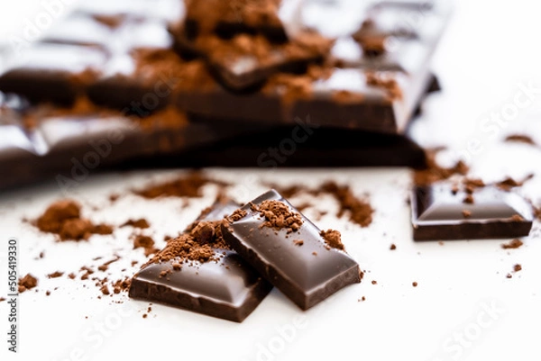 Fototapeta Close up view brown chocolate pieces and cocoa on white background.