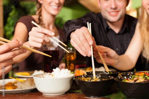 Obraz Młodzi ludzie jedzą w tajskiej restauracji