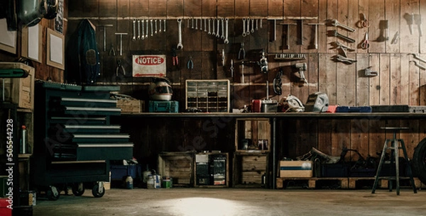 Fototapeta Workshop scene. Old tools hanging on wall in workshop, Tool shelf against a table and wall, vintage garage style