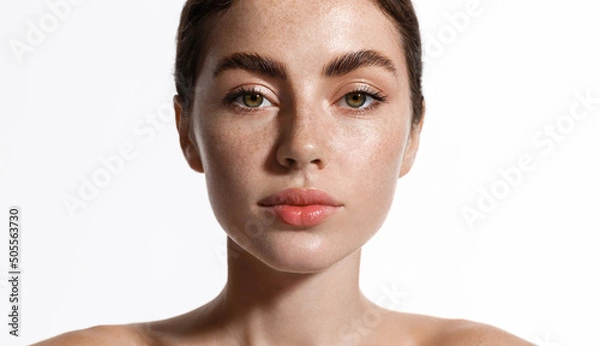 Obraz Skin care. Beauty woman with freckles, thick eyebrows and pink lips, has clear perfect skin, face with natural glow after cosmetic cream, spa effect, white background