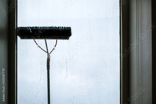 Obraz Window cleaning using telescopic water brush and wash system. Commercial window cleaning from the outside with sky in background. Defocused