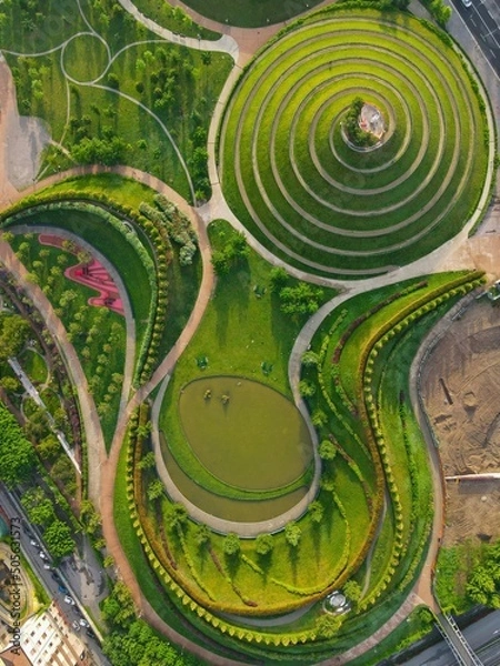 Fototapeta Aerial view of Parco del Portello in Milan, near CityLife, Lombardia. View from the height of park with a green lawn and paths. Abstract design similar to a dragon. Drone photography in Milano.