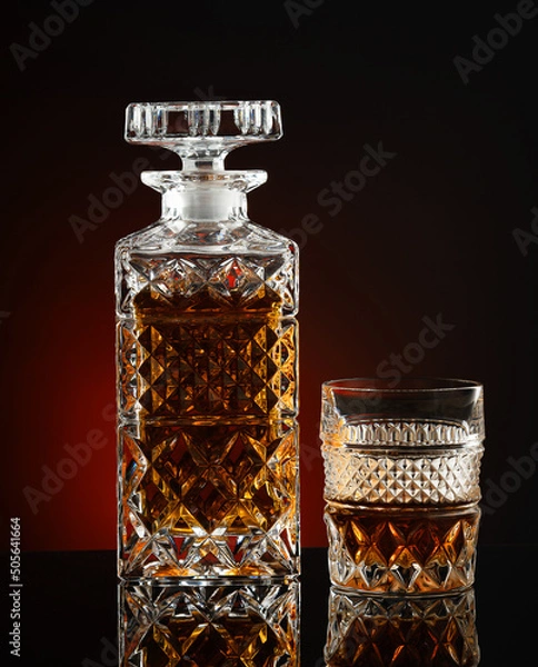 Fototapeta Decanter with whiskey or cognac and glass on black background