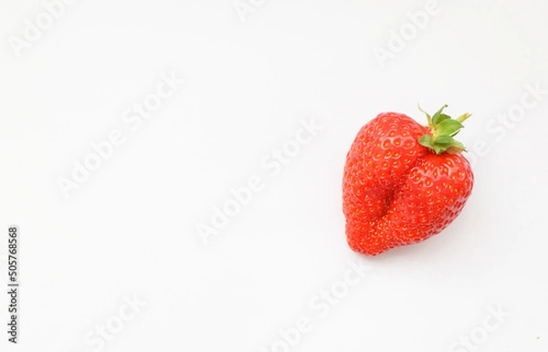 Fototapeta One fresh strawberries in the shape of a heart on a white background.Valentine's Day concept. Flat lay,copy space, top view.