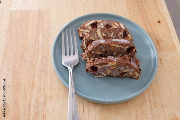 Fototapeta Homemade mosaic chocolate biscuit cake served in a blue plate, selective focus. It is called "Mozaik Pasta" in Turkish. That is texture of it not grain. Traditional Turkish dessert.