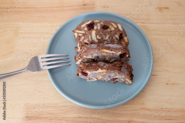 Fototapeta Homemade mosaic chocolate biscuit cake served in a blue plate, selective focus. It is called "Mozaik Pasta" in Turkish. That is texture of it not grain. Traditional Turkish dessert.
