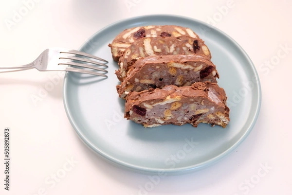 Fototapeta Homemade mosaic chocolate biscuit cake served in a blue plate, selective focus. It is called "Mozaik Pasta" in Turkish. That is texture of it not grain. Traditional Turkish dessert.