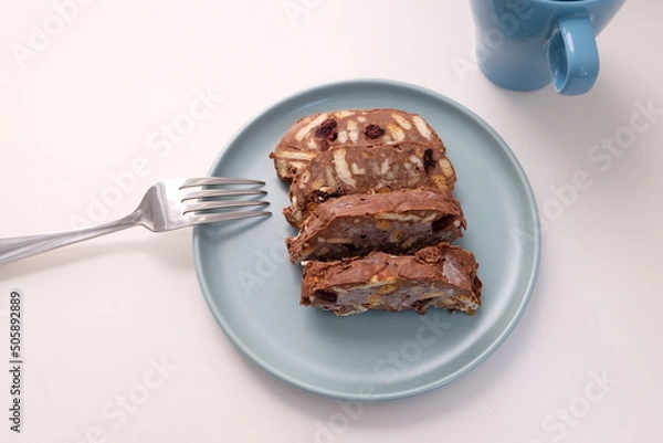 Fototapeta Homemade mosaic chocolate biscuit cake served in a blue plate, selective focus. It is called "Mozaik Pasta" in Turkish. That is texture of it not grain. Traditional Turkish dessert.
