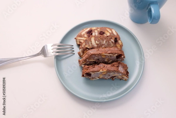 Fototapeta Homemade mosaic chocolate biscuit cake served in a blue plate, selective focus. It is called "Mozaik Pasta" in Turkish. That is texture of it not grain. Traditional Turkish dessert.
