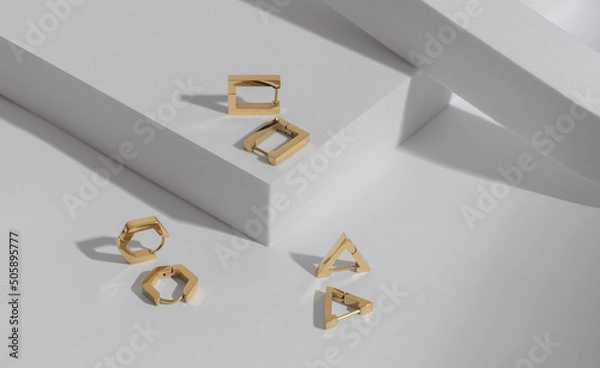 Fototapeta Top view of Three modern geometric shapes earrings pairs on white background with copy space