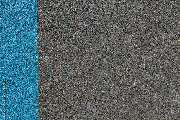 Fototapeta Blue and black rubber coating for playgrounds applied on the surface by a steel trowel. PDM rubber granules. Coating and floor covering for sports. Rubber mulch for safety and injury prevention