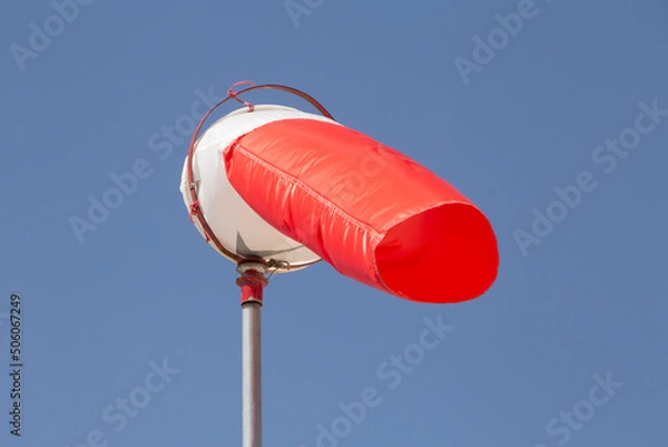Fototapeta red windsock against clear blue sk