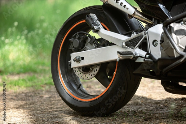 Fototapeta motorcycle wheel on the ground in the forest at sunset