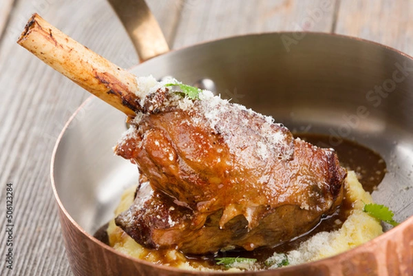 Obraz Juicy roasted duck leg with mashed potatoes in a serving frying pan.