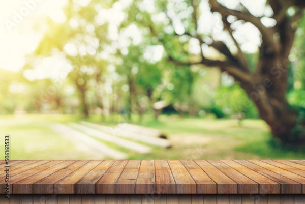 Obraz Empty wooden table top and Abstract blurred light bokeh and blur background of garden trees in sunlight. product display template with copy space.