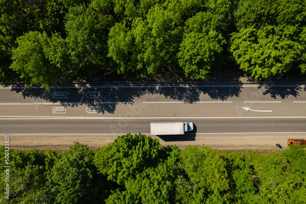 Fototapeta Road through the green forest, aerial view car drive going through forest, top down view forest, view from above, ecosystem and healthy environment concept and background.