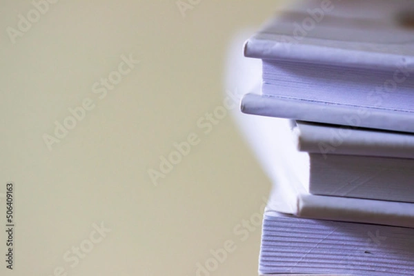 Obraz Stack of white books on light background. Close up of books. Free copy space.