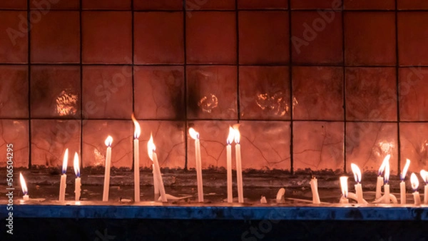 Fototapeta candles burning inside the church. christian ceremony. Close up