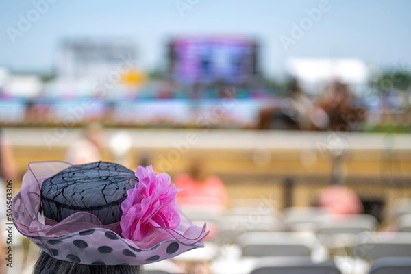 Obraz An attendee at a horse race, wearing a fancy hat.