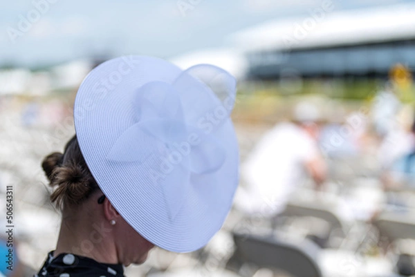 Obraz An attendee at a horse race, wearing a fancy hat.