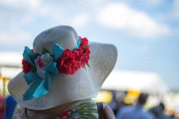 Obraz An attendee at a horse race, wearing a fancy hat.