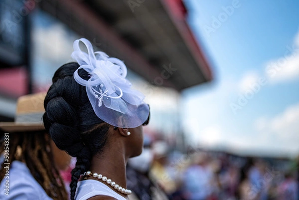 Obraz An attendee at a horse race, wearing a fancy hat.