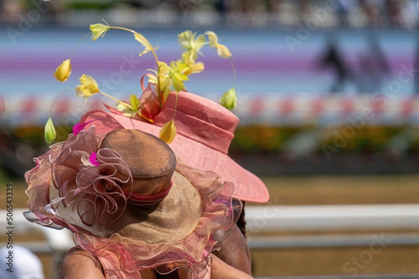 Obraz A couple of attendees at a horse race, wearing fancy hats.