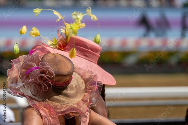 Obraz A couple of attendees at a horse race, wearing fancy hats.