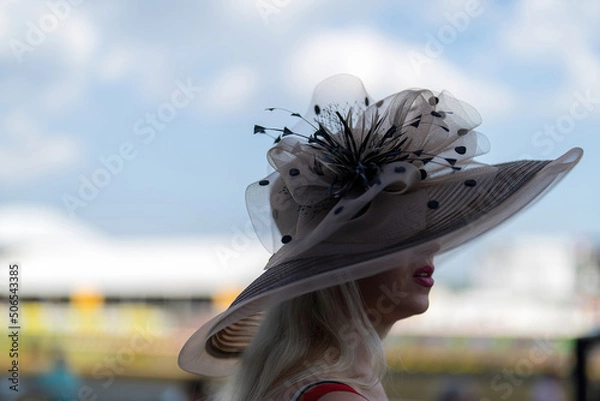 Obraz An attendee at a horse race, wearing a fancy hat.