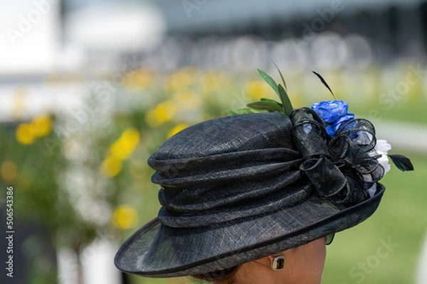 Obraz An attendee at a horse race, wearing a fancy hat.